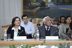 This image shows a close-up of two key participants at a formal event, probably the same conference as in the previous image. The atmosphere is focused and professional.