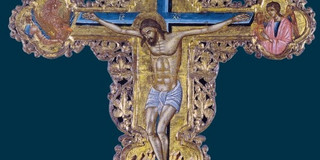Exhibition poster with an artistically decorated crucifix icon on a dark blue background. At the top is the German title “Eastern Christian art from border regions – Belarus, Ukraine, Romania, Western Balkans, Greece”, and at the bottom is the English title “Icons in-between – Eastern Christian art from border areas, Belarus, Ukraine, Romania”.