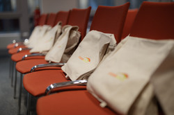 Bags with gifts for the alumni are placed on the seats shortly before the event begins.